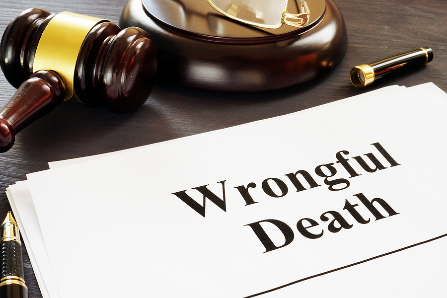 wrongful death written on paper sitting on desk next to gavel