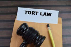 Concept of Tort Law written on paperwork with gavel isolated on wooden background.