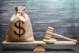 A bag of dollar and attorney hammer on scale