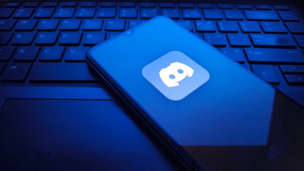A smartphone displaying the Discord app logo on a laptop keyboard, representing digital evidence managed by Boca Raton Discord Sexual Abuse Lawsuit Lawyers.