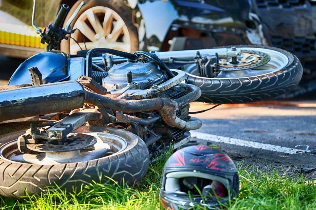 A motorcycle lying on its side on the pavement next to a helmet after an accident, highlighting a crash scene involving the "I didn't see the motorcycle" defense in Boca Raton.
