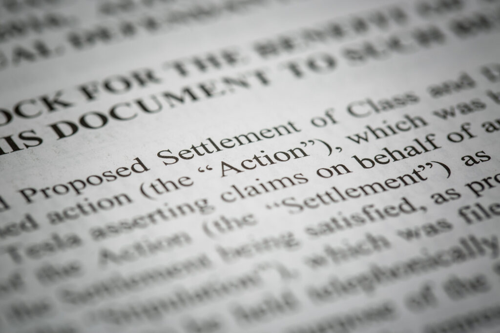 Close-up of a legal document highlighting a proposed settlement, representing claims handled by Olympus Scopes Lawsuit Lawyers.