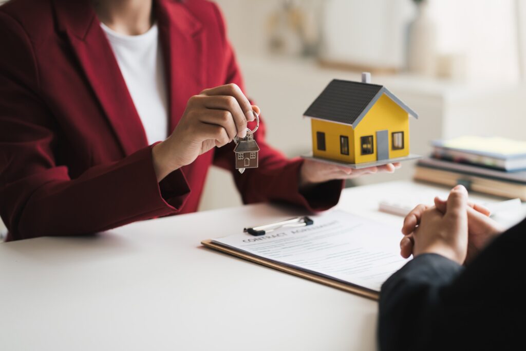 A real estate professional holding house keys over a contract reviewed by Florida timeshare exit and cancellation attorneys.